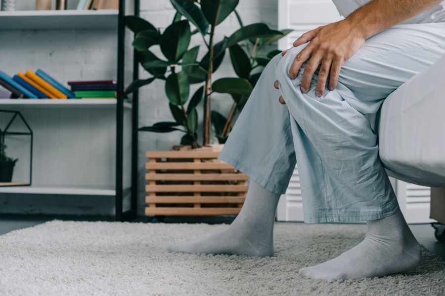 man with lyme disease and arthritis rubbing his knee