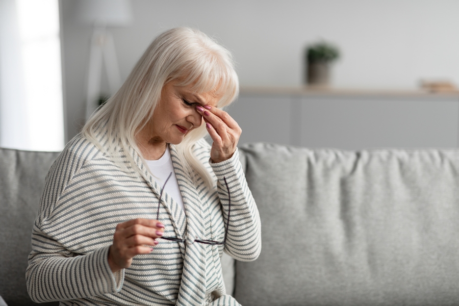 Woman with untreated Babesia infection holding her head.