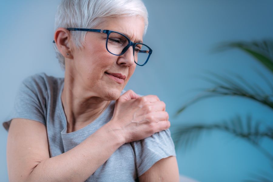 Woman rubbing painful shoulder due to Lyme meningitis.