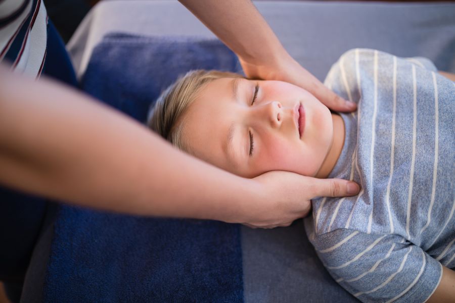 Boy getting massage for neck pain due to Lyme disease.