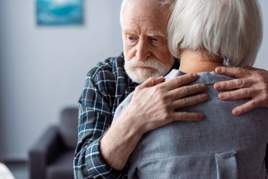 Elderly man with dementia and Lyme disease hugging his wife.