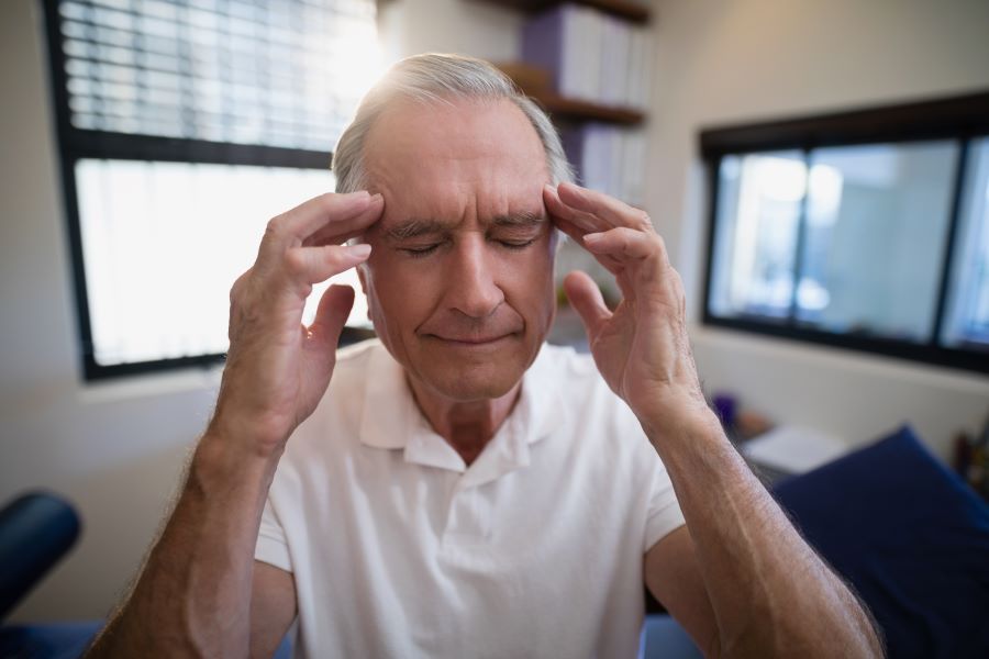 Man with Lyme disease affecting his brain is holding his head.