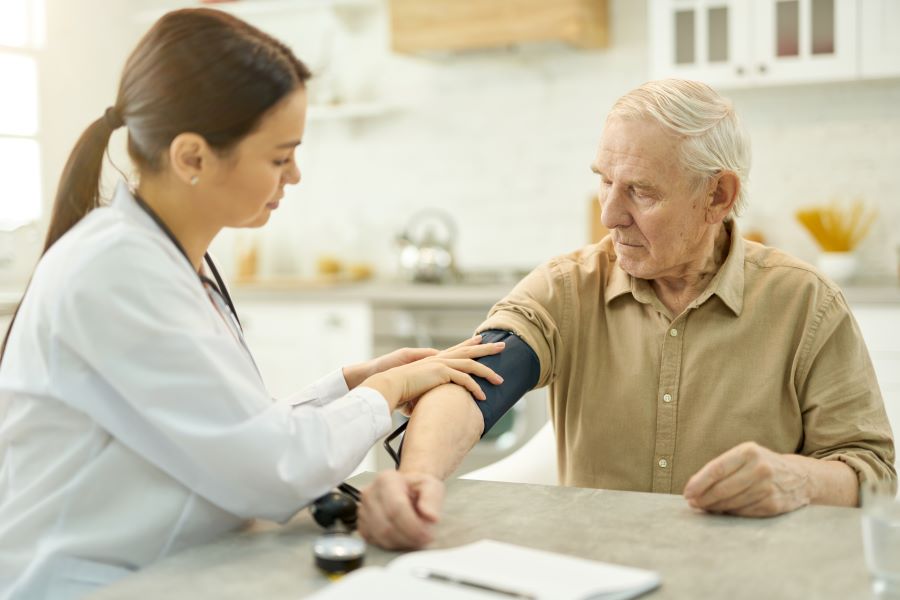 Elderly man with Babesia infection getting blood pressure tested.