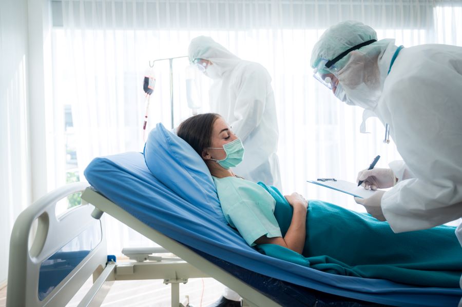 Woman with Lyme disease and COVID-19 being examined in hospital bed.