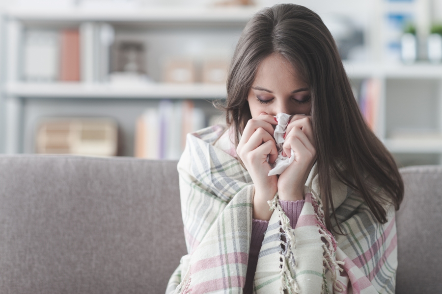 Sick woman sitting on couch with disseminated Lyme disease