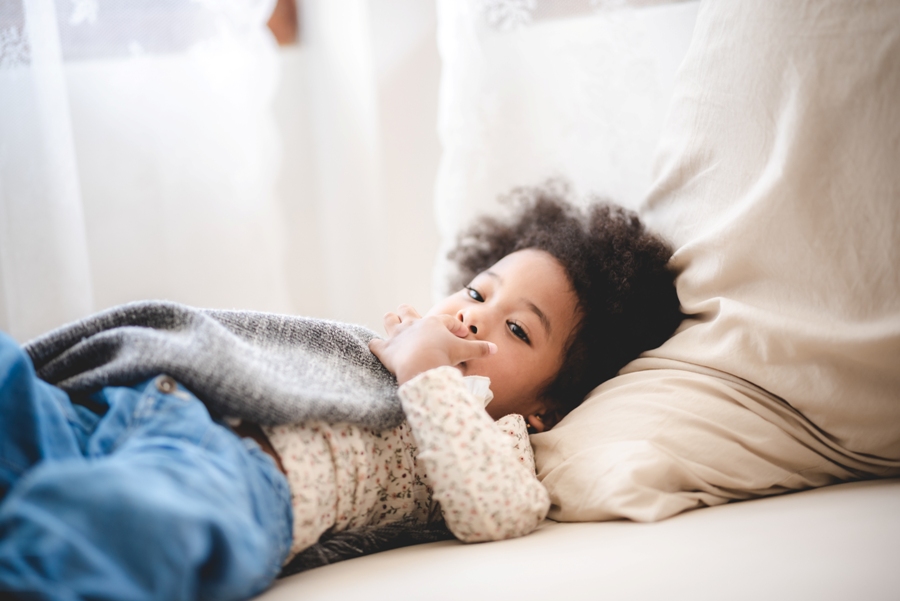 African American child with Lyme disease laying in bed