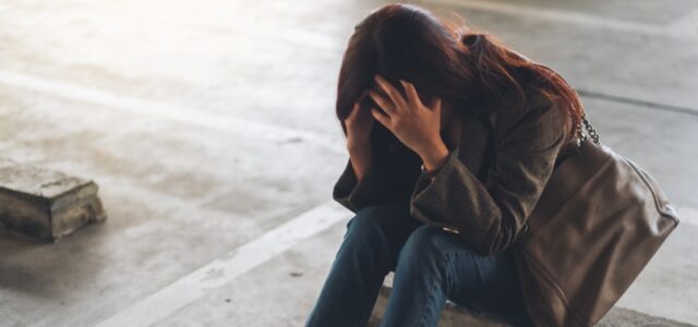 woman with lyme disease and vertigo sitting and holding head