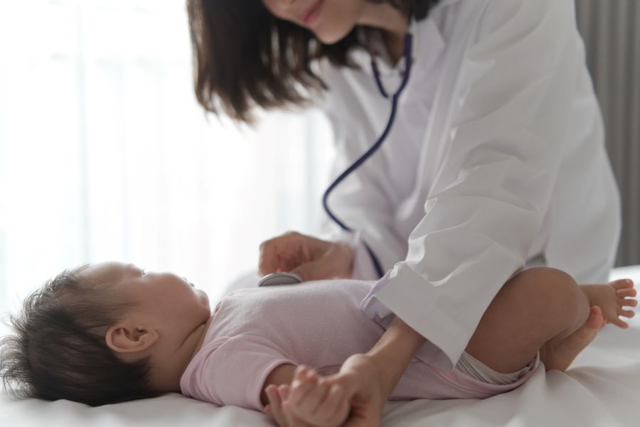 Newborn with lyme disease and herxheimer reaction being examined by doctor.