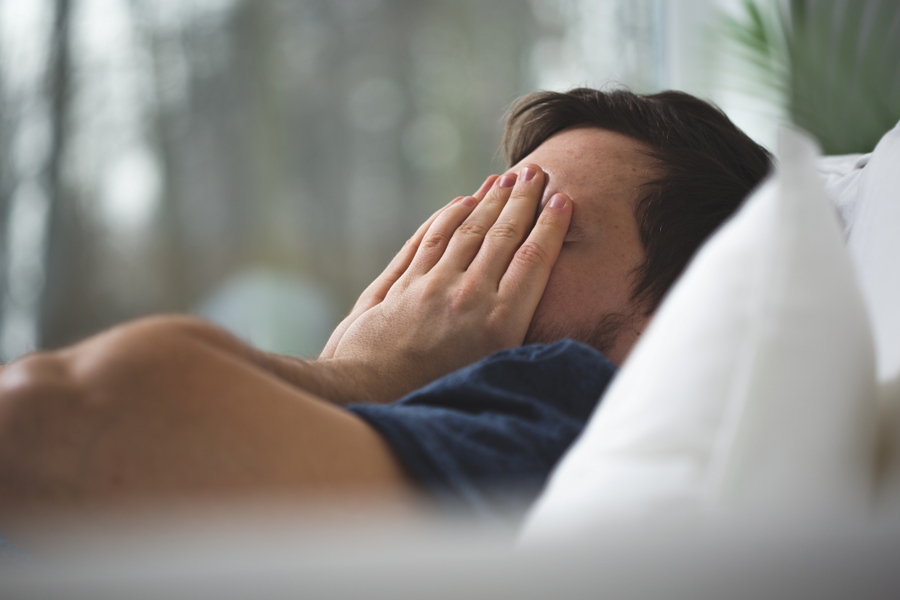 Lyme disease presentation in man from Germany holding his hands over his face.