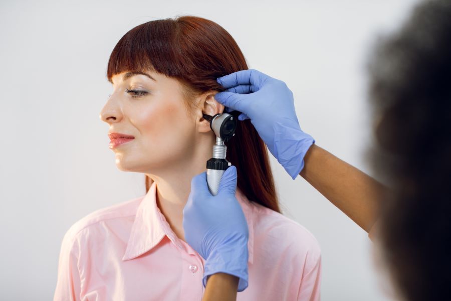 Woman with Lyme meningitis getting an ear exam.