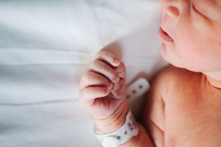 Newborn infant in hospital bed.