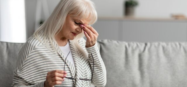 Woman with untreated Babesia infection holding her head.