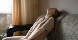 woman resting on couch sunlight chronic illness