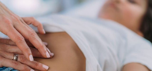 doctor examining child with abdominal pain and possible Lyme disease symptoms