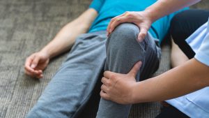 Doctor examining swollen knee in child with possible Lyme arthritis