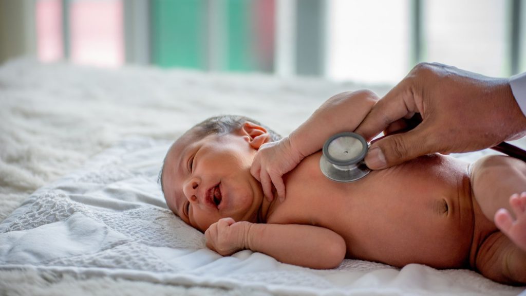 Pediatrician examining an infant during evaluation for possible Lyme disease or Babesia infection.