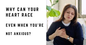 Woman sitting at home with her hand on her chest while experiencing a racing heartbeat