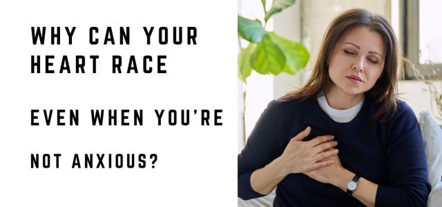 Woman sitting at home with her hand on her chest while experiencing a racing heartbeat